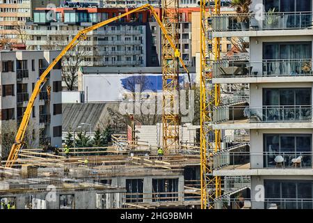 Construction workers install formwork and iron rebars or reinforcing bars for reinforced concrete partitions at residential building construction site Stock Photo