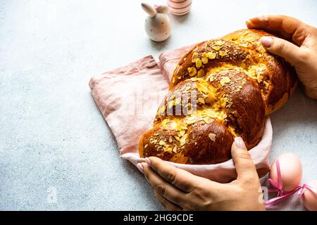 Close-up of a woman holding a traditional tsoureki Easter loaf with almonds Stock Photo