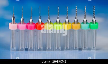 Set of twist micro drill bits on a white-blue background. Metal tools kit in color coded plastic box. Toolkit for drilling small holes. Microdrilling. Stock Photo