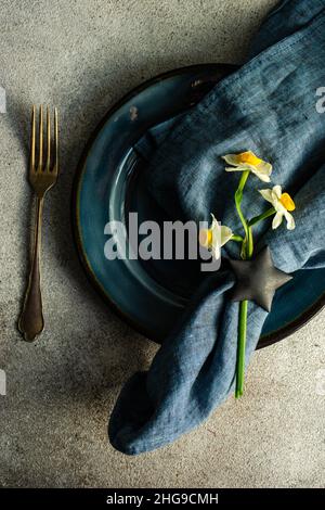 Overhead view of a rustic Easter place setting with a narcissus flower Stock Photo