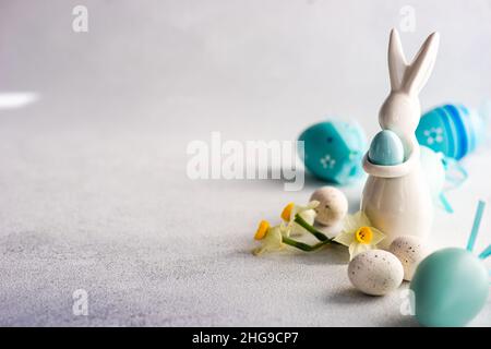 Painted Easter egg and Easter bunny decorations on a table with narcissus flower Stock Photo
