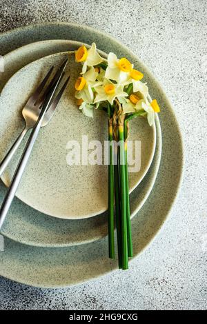 Overhead view of an Easter place setting with narcissus flowers Stock Photo