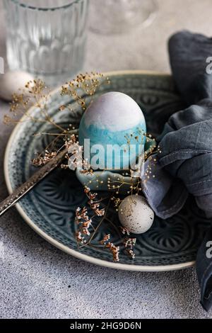 Festive Easter place setting with painted Easter eggs and dried flowers Stock Photo
