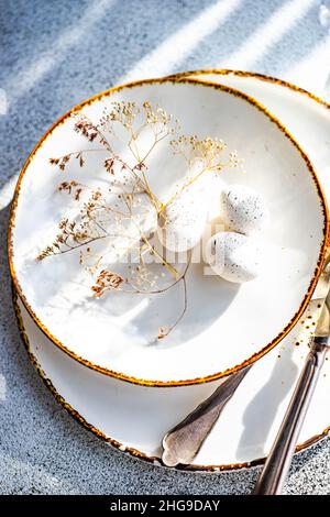 Overhead view of an Easter place setting with eggs and dried flowers on a table Stock Photo