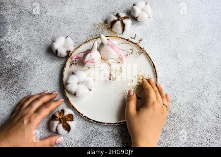 Overhead view of a woman setting a table with Easter decorations Stock Photo