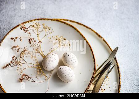 Overhead view of an Easter place setting with eggs and dried flowers on a table Stock Photo