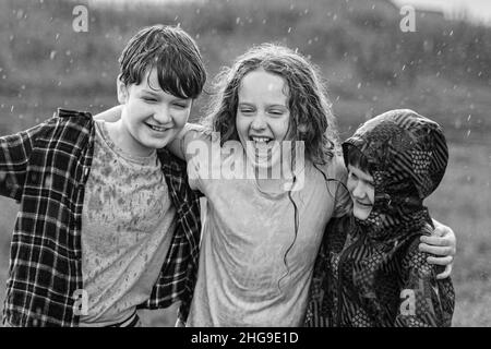 Black and white portrait. Children smile hugging outdoors. Friendship concept. Stock Photo