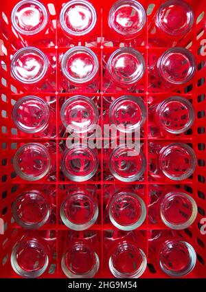 A lot of clean drinking glasses are collected in the red plastic crate to use in the local restaurant, front view with the copy space. Stock Photo
