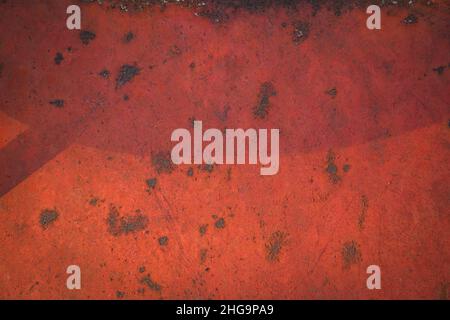 Rusty metal surface covered with red paint with spots. Worn background with rusty metal texture. Stock Photo