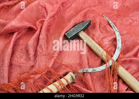 Hammer and Sickle on the red fabric. Symbol of the communist movement Stock Photo