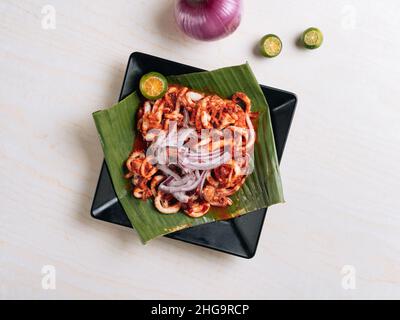 Korean BBQ squid calamary with raw onion and lemon Traditional korean dish. on grey background top view Stock Photo