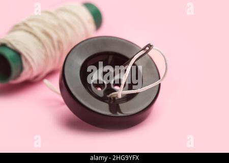 Colored buttons and a thread spool in a tree shape on a white background in a close up view Stock Photo