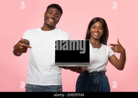 Black couple showing blank empty laptop screen for mock up Stock Photo