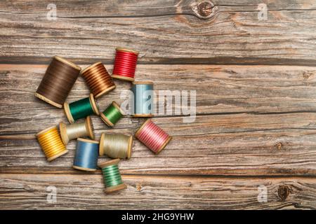 Colored thread spools on a wooden background with copy space Stock Photo