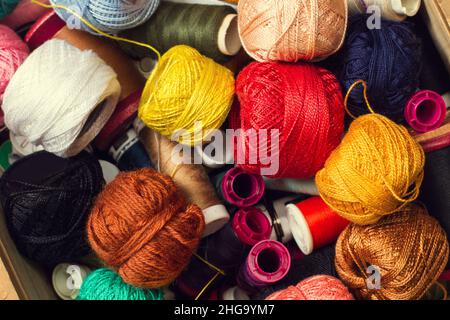 Colored thread spools and yarn balls in a close up view Stock Photo