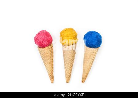 Colored wool balls on wafer cones ice cream shape on a white background Stock Photo