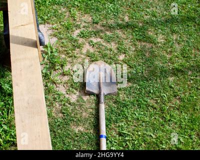 bayonet shovel lies on the ground in the garden, in summer Stock Photo