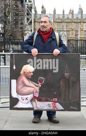 London, UK. 19/01/2022,  Satirical artist, Kaya Mar, poses with his latest portrait of Prime Minister Boris Johnson outside of the Houses of Parliament. The painting comments on both Partygate and the freezing of the BBC licience fee. Stock Photo