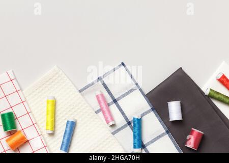 Fabric and threads on a gray background. Top view flat lay copy space Stock Photo
