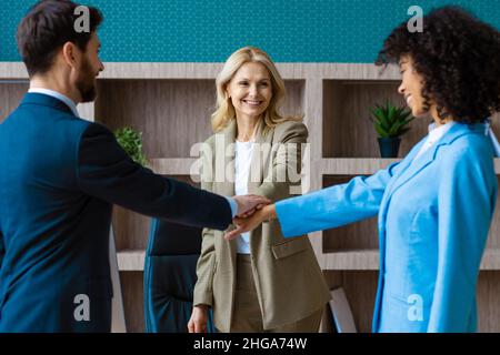 Multiracial group of businesspeople with elegant dress sitting at computer desk in the office - Diverse people   working at laptop online in the meeti Stock Photo