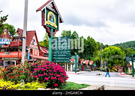 Helen, USA - October 5, 2021: Helen, Georgia Bavarian village traditional German architecture roof and colorful house and direction sign for restauran Stock Photo