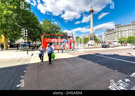 London, UK - June 21, 2018: Trafalgar square with Nelson's column and people outside on sunny summer day with red double decker bus wide angle view Stock Photo