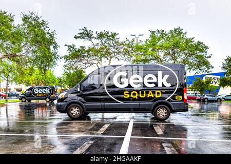 Miami, USA - July 12, 2021: Sign advertisement for Best Buy store on exterior building facade and Geek Squad repair van truck in parking lot in Florid Stock Photo