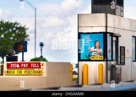 Miami, USA - August 5, 2021: SunPass Sun Pass red stop pay for toll watch for pedestrians sign with Progressive insurance advertisement on i-75 road F Stock Photo