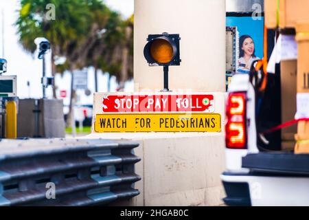 Miami, USA - August 5, 2021: SunPass Sun Pass red stop pay for toll watch for pedestrians sign with security cameras on i-75 road Florida interstate h Stock Photo