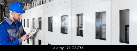 Male Technician Doing Meter Reading Using Tablet Stock Photo