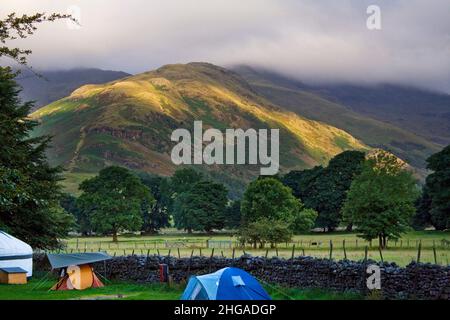 Lake district cumbria's national park UK, great langdale camp site view golden sun lit hills thick mist scenic view