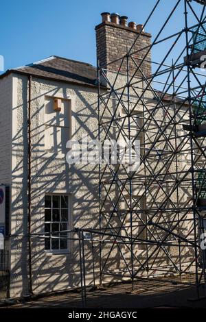 Scaffolding blocks an entire road - erected to stop an old decayed listed building opposite from injuring people with falling stone. Kelso, Scotland. Stock Photo