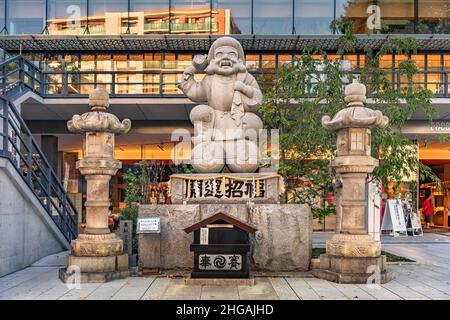 tokyo, japan - September 17 2019: Stone statue of one of the Seven Lucky Gods, Daikokuten surrounded by lanterns in front of the Edocco Edo Culture Co Stock Photo