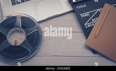 Close up of a vintage clapboard with laptop and filmstrip. Stock Photo