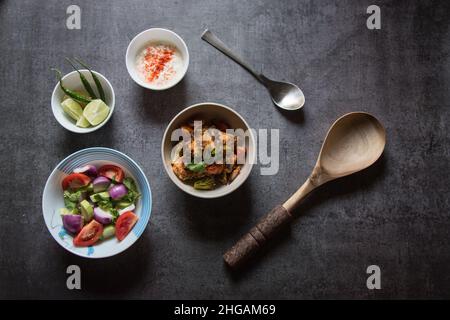 Indian lunch menu dum aloo or potato masala, pulao or vegetable fried rice and paneer or cottage cheese served with salad and condiments. Top view. Stock Photo