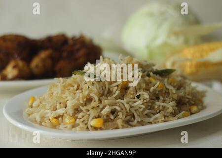 Cabbage corn fried rice. A tasty rice dish with sauteed cabbage and corn flavoured with garlic. A quick meal option served with chicken roast prepared Stock Photo