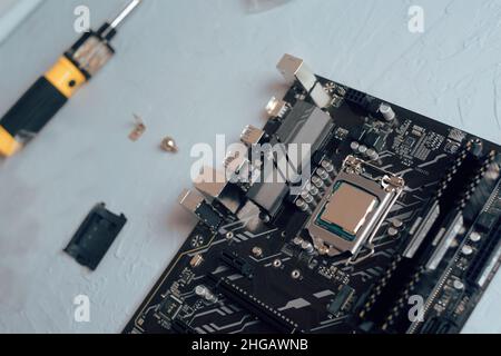 Engineer plugging CPU microprocessor to motherboard socket. Computer technology hardware maintenance or repair.  Electronics Development Working on Co Stock Photo
