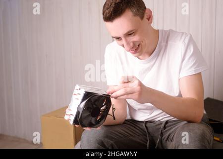 Computer technician installs cooling system of computer. Engineer repairing computer (pc) board. Technician plug in electronic parts on motherboard.A Stock Photo