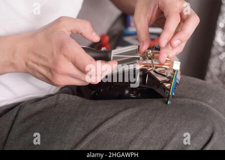 Computer technician installs cooling system of computer. Engineer repairing computer (pc) board. Technician plug in electronic parts on motherboard.A Stock Photo