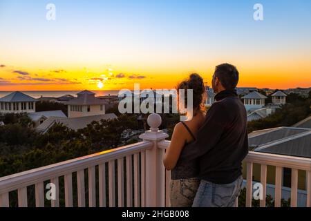 High angle view on colorful sunset paradise with young couple woman man watching looking at view on Gulf of Mexico in Seaside, Florida on rooftop terr Stock Photo