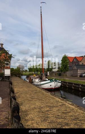 Water canal for boats between houses in Hindeloopen in Holland. Stock Photo