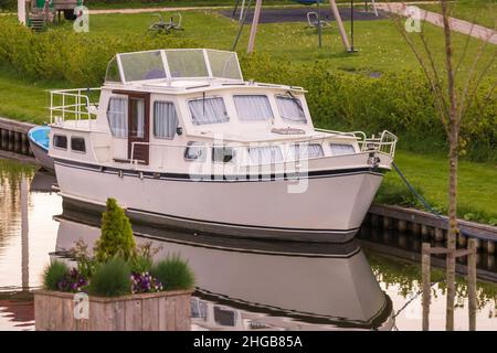 Boat - Hausbot on a canal in Hindeloopen, Holland. The ship is reflected in the water. Stock Photo