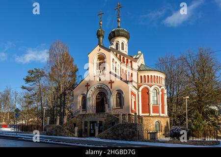 Marienbad, Czech Republic - January 6 2022: View of the Orthodox Russian church with yellow and red facade. Sunny winter day with blue sky and clouds. Stock Photo