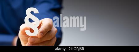 Close-up Of A Businessperson's Hand Holding Paragraph Symbol Stock Photo
