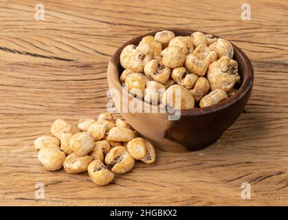 Canjica, hominy or white corn popcorn, sweet popcorn in a bowl over wooden table. Stock Photo