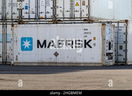 Maersk shipping containers with company logo signage. White refrigerated crates used to transport or ship chilled goods or freight. Ireland