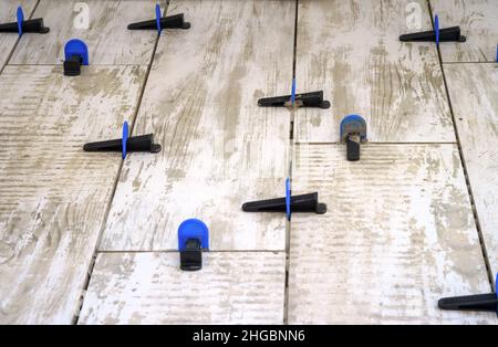 Apparatus for laying stoneware tiles. Leveling system for installing ceramic tiles.. Stock Photo
