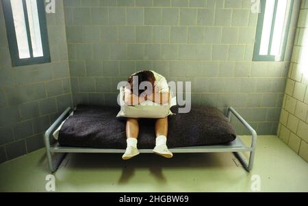 Austin, Texas  USA 1989  Illustration using a model showing juvenile justice in Texas.  Anglo teen (model released) in a holding cell. MR RE-321-322. Stock Photo