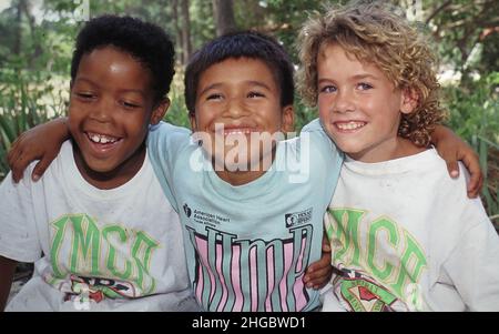 Austin, Texas USA 1990: Children, ages 8-9 showing friendship.  One Black, one Hispanic and one Anglo. XX Stock Photo