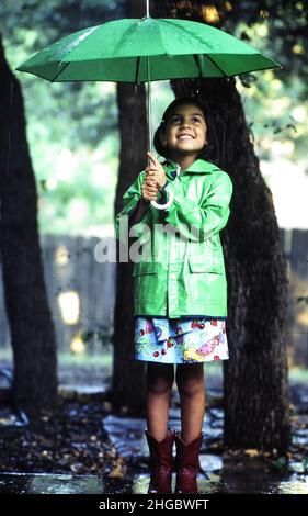 Austin, Texas USA  1990: Hispanic girl, 8 in the rain. Model released.   XX Stock Photo